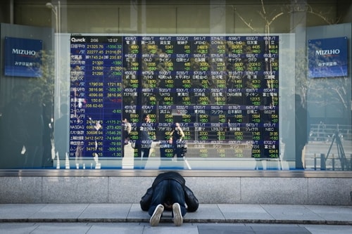 Phản ứng của một người Nhật khi nhìn bảng điện tử chứng khoán sáng nay. Ảnh: Bloomberg