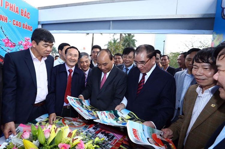 Thủ tướng Nguyễn Xuân Phúc xem ấn phẩm báo chí của các địa phương. Ảnh: Thống Nhất/TTXVN