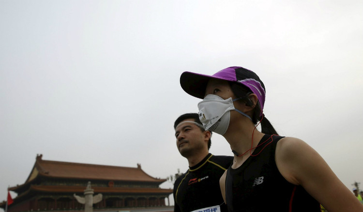 Runner phải đeo khẩu trang vì ô nhiễm không khí ở Bắc Kinh. Ảnh: Reuters