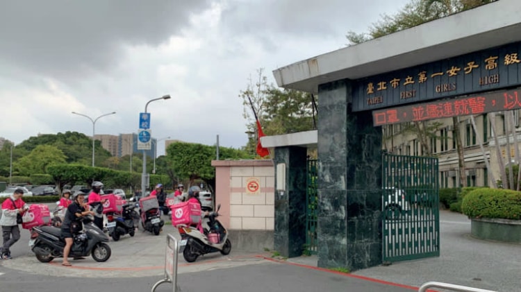 Hàng loạt xe máy giao thức ăn của Foodpanda bên ngoài cổng trường nữ sinh Đệ nhất Đài Bắc vào buổi trưa.