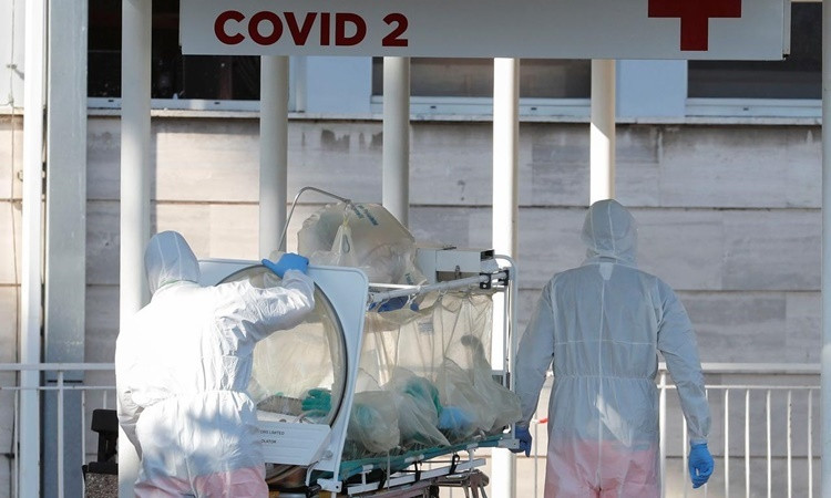 Nhân viên y tế di chuyển một bệnh nhân nhiễm nCoV trên cáng cách ly tại phòng khám Columbus ở Rome, Italy, ngày 16/3. Ảnh: Reuters.