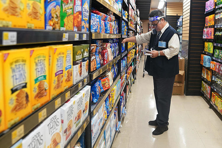 Nhân viên kiểm tra hàng hóa trên kệ tại một cửa hàng tạp hóa ở Manhattan, New York City, New York, Mỹ hôm 7/8. Ảnh: Reuters.