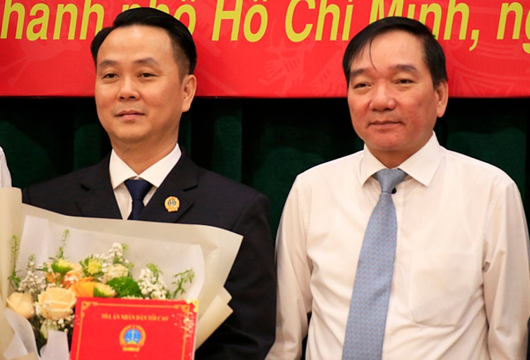 Ông Trần Anh Tuấn, Vụ trưởng Vụ Tổ chức - Cán bộ TAND Tối cao (phải) trao quyết định cho ông Nguyễn Thành Vinh. Ảnh: Hữu Công.