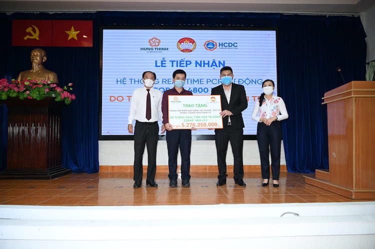 Ông Nguyễn Nam Hiền - Phó Tổng Giám đốc Tập đoàn Hưng Thịnh trao tặng hệ thống máy xét nghiệm tự động Real-time PCR cho Bác sĩ Nguyễn Hồng Tâm - Phó Giám đốc Trung tâm kiểm soát bệnh tật TP.HCM với sự chứng kiến của Bác sĩ Nguyễn Hoài Nam - Phó Giám đốc Sở Y tế TP.HCM và Bà Phan Kiều Thanh Hương - Phó Chủ tịch Ủy ban MTTQ Việt Nam TP.HCM