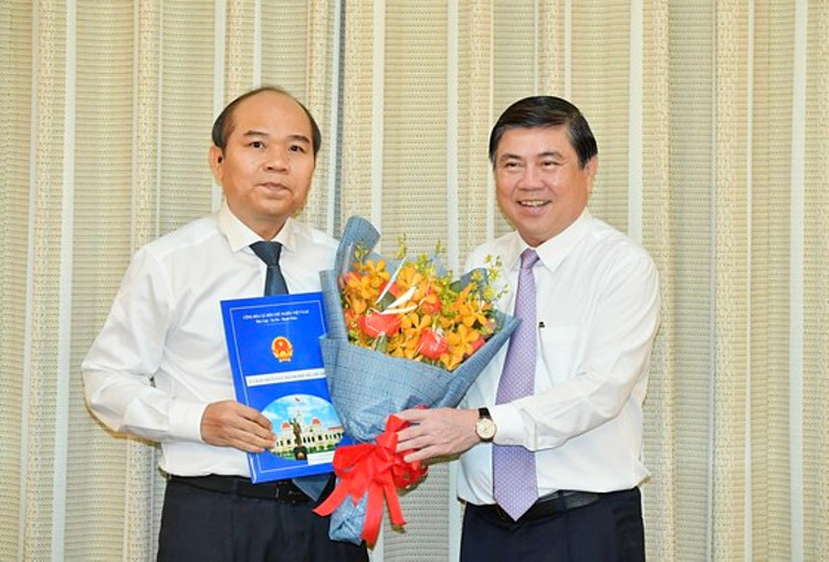 Chủ tịch UBND TP.HCM Nguyễn Thành Phong (bìa phải) trao quyết định cho ông Trần Văn Bảy