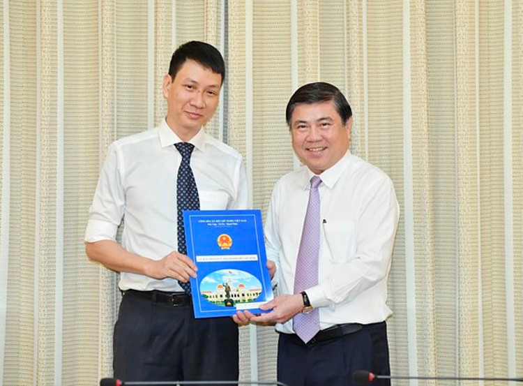 Chủ tịch UBND TP.HCM Nguyễn Thành Phong (bìa phải) trao quyết định cho ông Trương Trung Kiên. Ảnh: Việt Dũng