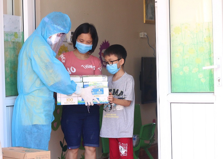 Người dân, trẻ em trong nơi cách ly tập trung tại huyện Thuận Thành, một trong những điểm nóng về dịch ở Bắc Ninh, đón nhận món quà từ Vinamilk