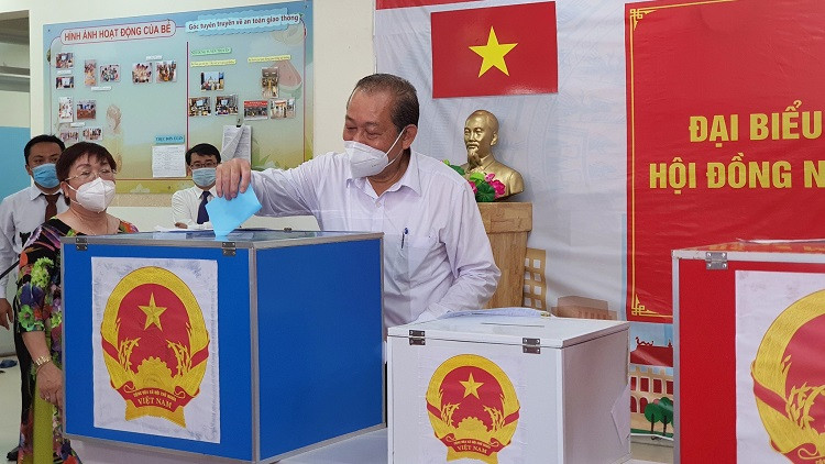 [Caption]Phó thủ tướng thường trực Trương Hòa Bình bỏ lá phiếu bầu cử đầu tiên tại điểm bầu cử Trường mầm non 7, Q.Tân Bình, TP.HCM