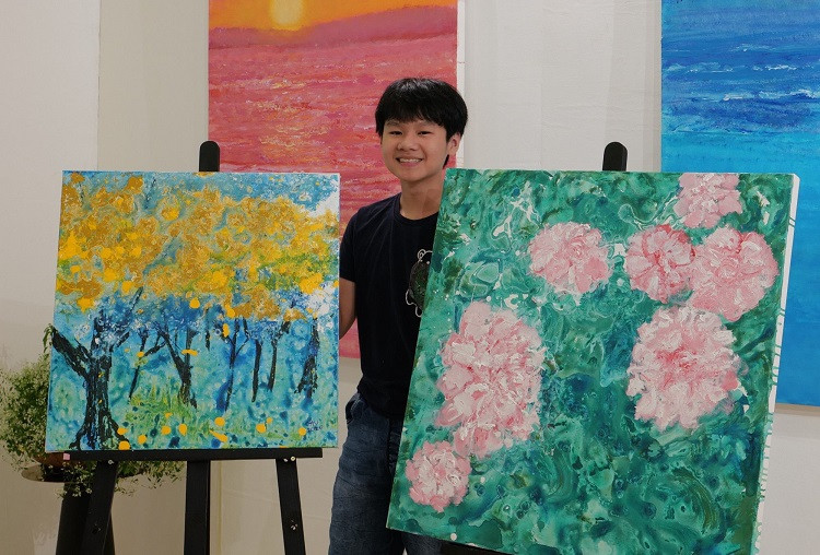 Hoạ sĩ Xèo Chu bên các tác phẩm nghệ thuật của mình