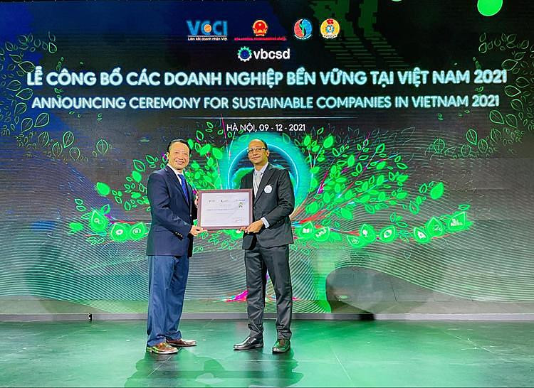 Tổng thư ký VCCI, Phó chủ tịch điều hành VBCSD Nguyễn Quang Vinh (bìa trái) chúc mừng Giám đốc Chuỗi cung ứng, đại diện công ty Mondelez Kinh Đô Anand Jakati.