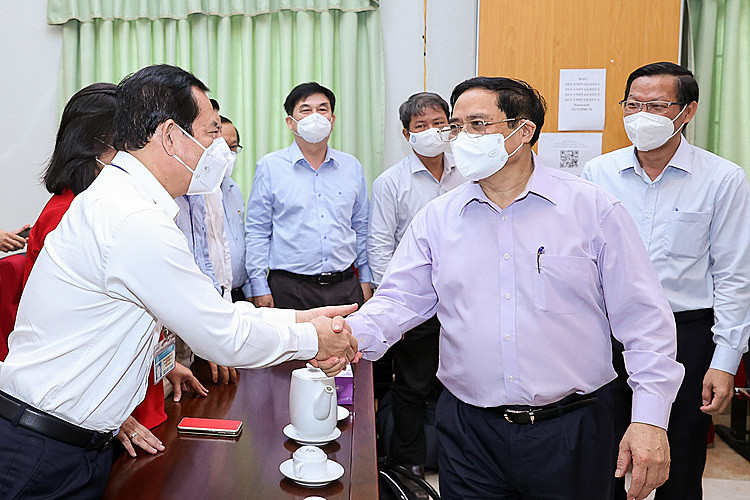 Thủ tướng Phạm Minh Chính thăm hỏi cán bộ ngành y tế TP. Ảnh: VGP/Nhật Bắc