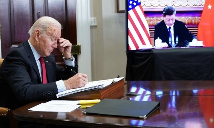 Tổng thống Mỹ Joe Biden và Chủ tịch Trung Quốc Tập Cận Bình (trên màn hình) họp thượng đỉnh trực tuyến hồi tháng 11/2021. Ảnh: AFP.