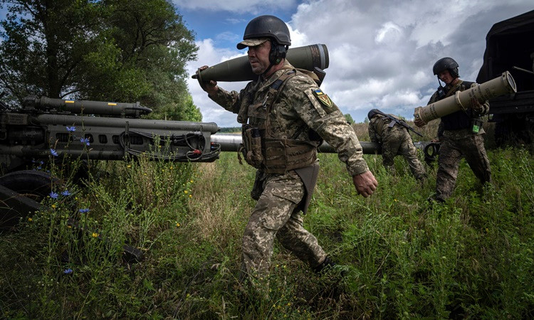Các quân nhân Ukraine điều khiển lựu pháo M777 do Mỹ viện trợ tại vùng Kharkov phía đông bắc hôm 13/7. Ảnh: AP.