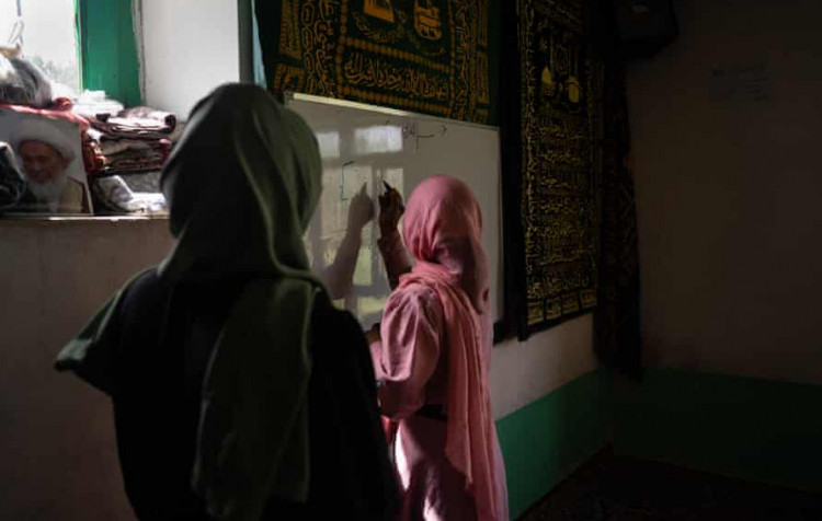 Một bé gái tham gia một lớp học bí mật tại Afghanistan. Ảnh: Guardian.