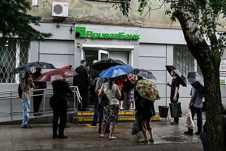 Người dân xếp hàng bên ngoài ngân hàng để rút tiền ở trung tâm thành phố Kramatorsk ngày 11/7. Ảnh: AFP.