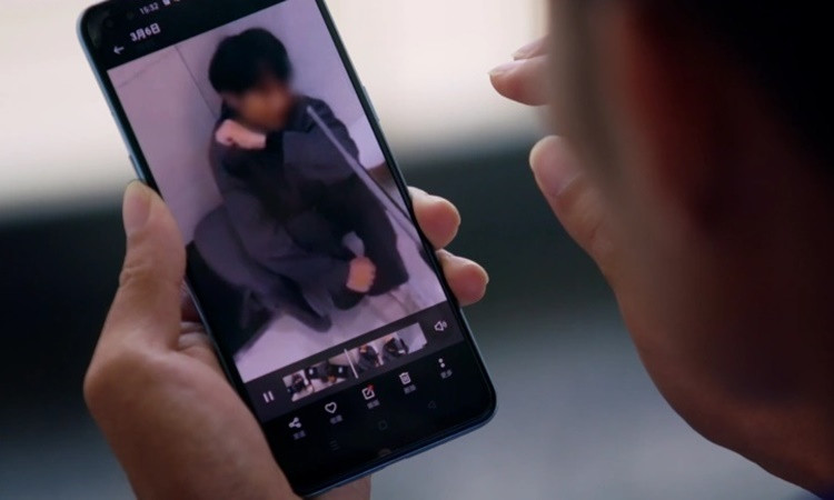 Màn hình điện thoại hiển thị video về một người đàn ông bị hành hạ trong một đường dây lừa đảo ở Campuchia. Ảnh: Al Jazeera.