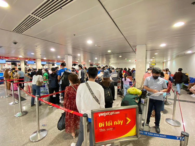 Hành khách đứng hàng dài để chờ tới lượt làm thủ tục lên tàu bay tại quầy vé của một hãng hàng không.