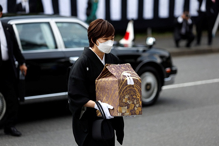 Phu nhân Akie của cố Thủ tướng Abe mang tro cốt tới giao cho Thủ tướng Kishida Fumio mang vào nơi tổ chức quốc tang. Ảnh: Reuters.