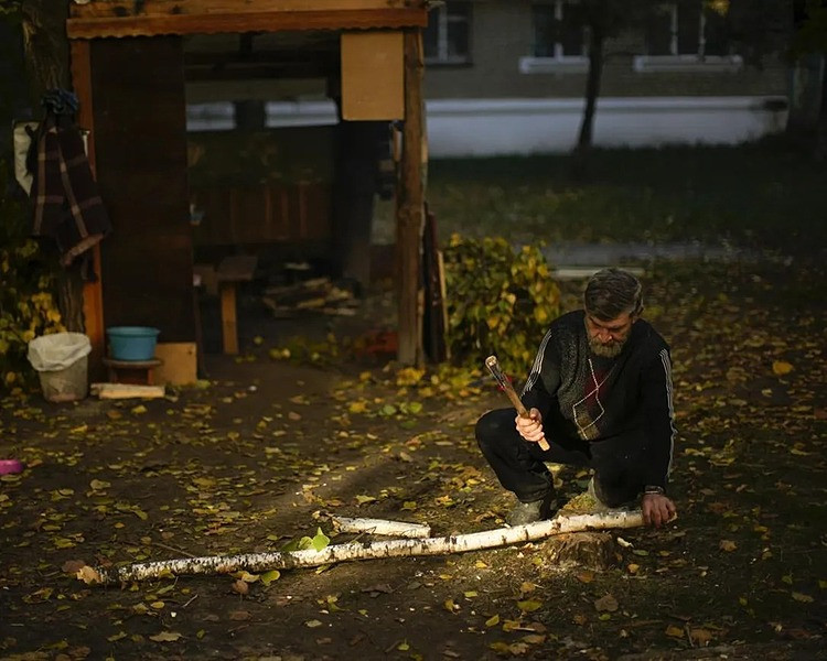Người đàn ông chặt củi ở Kivsharivka ngày 16/10. Ảnh: AP