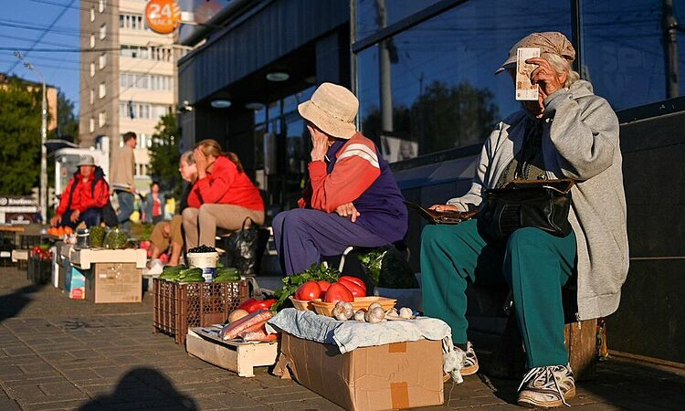 Người bán hàng ngồi trên một con phố ở Izhevsk, Nga hồi tháng 8. Ảnh: Reuters.