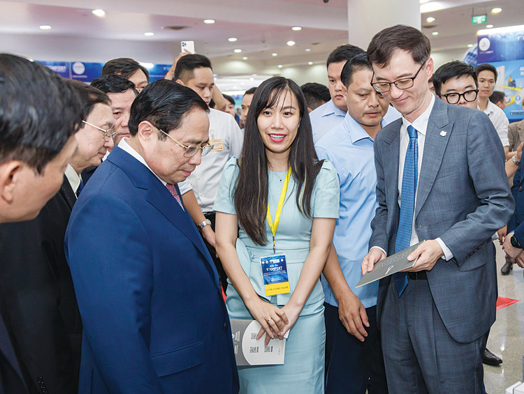Thủ tướng Phạm Minh Chính, Bộ trưởng Bộ Khoa học và Công nghệ Huỳnh Thành Đạt tham quan gian hàng trưng bày của chương trình Shinhan Square Bridge Việt Nam tại TECHFEST