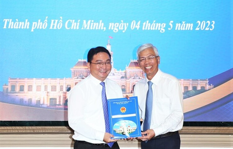 Ông Nguyễn Trần Bình (bên trái) nhận quyết định bổ nhiệm làm Chủ tịch UBND Q.11, TP.HCM