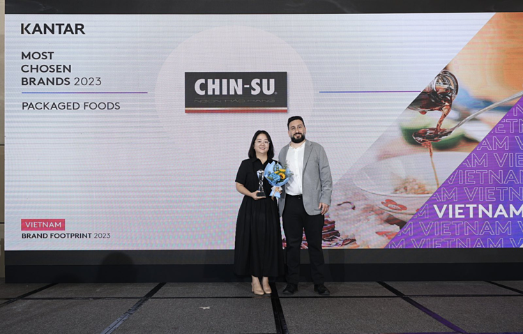 Đại diện của nhãn hàng Chin-su (bên trái) nhận chứng nhận từ đại diện Kantar World Panel