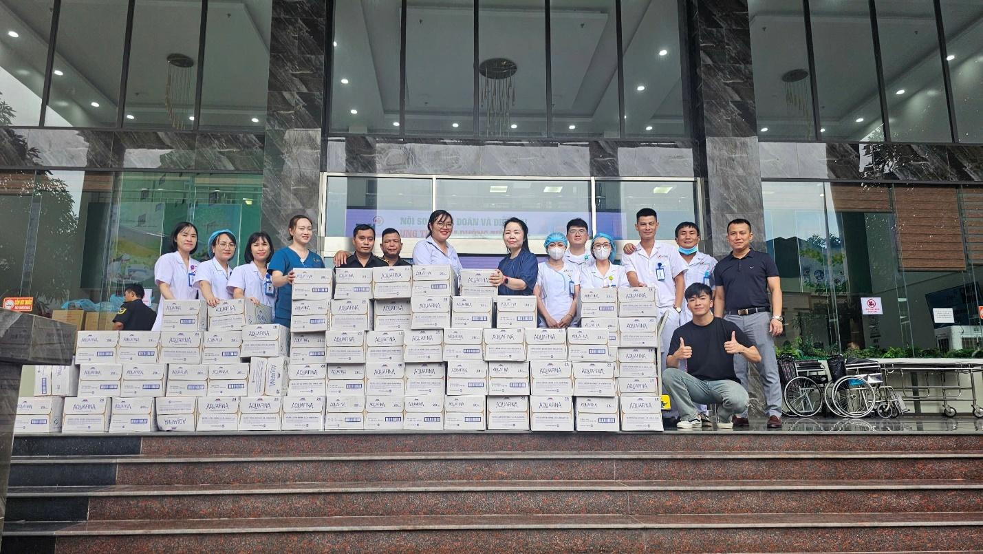 A group of people standing on steps with boxes Description automatically generated