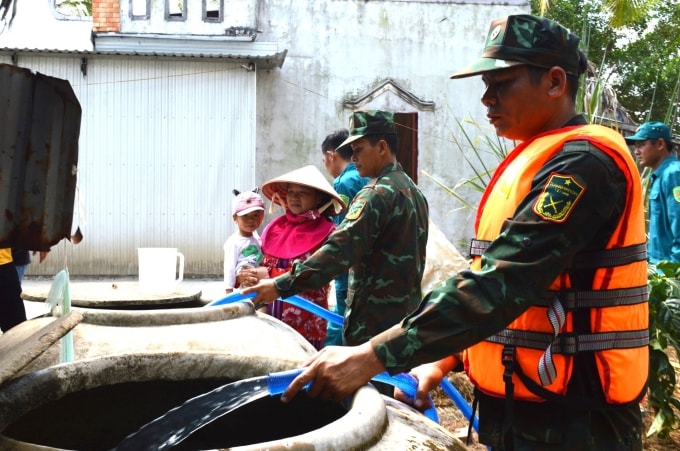Bộ đội cấp nước miễn phí cho người dân ở xã Biển Bạch, huyện Thới Bình. Ảnh: Chúc Ly