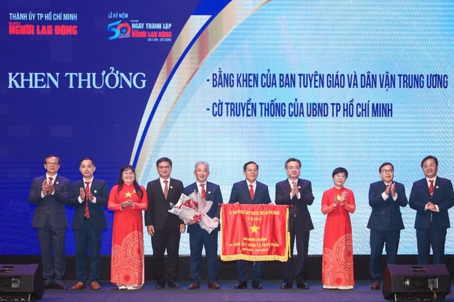 Phó bí thư Thường trực Thành ủy TP.HCM Nguyễn Thanh Nghị trao cờ truyền thống cho Ban Biên tập Báo Người Lao Động. Ảnh: B.T.C