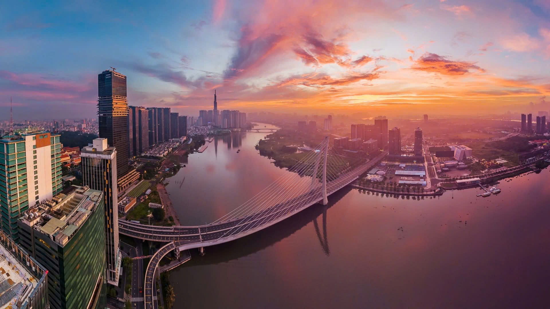 Bình minh đỏ rực phủ lên những khối nhà cao thấp bên sông Sài Gòn.