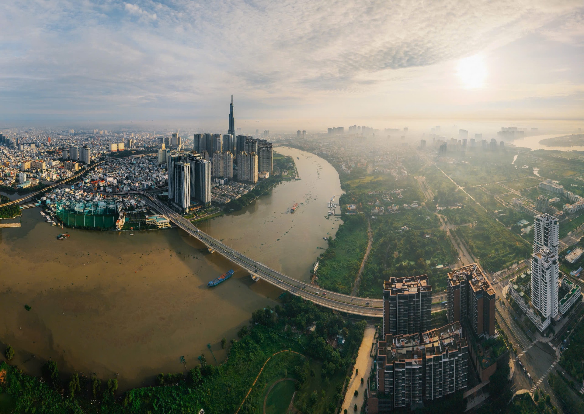 Cầu Thủ Thiêm nhìn từ trên cao với 2 mảng đối lập 1 bên là các tòa nhà bê tông bao phủ diện rộng, 1 bên vẫn còn chút khoảng xanh để thở. Ảnh Nguyễn Đạt