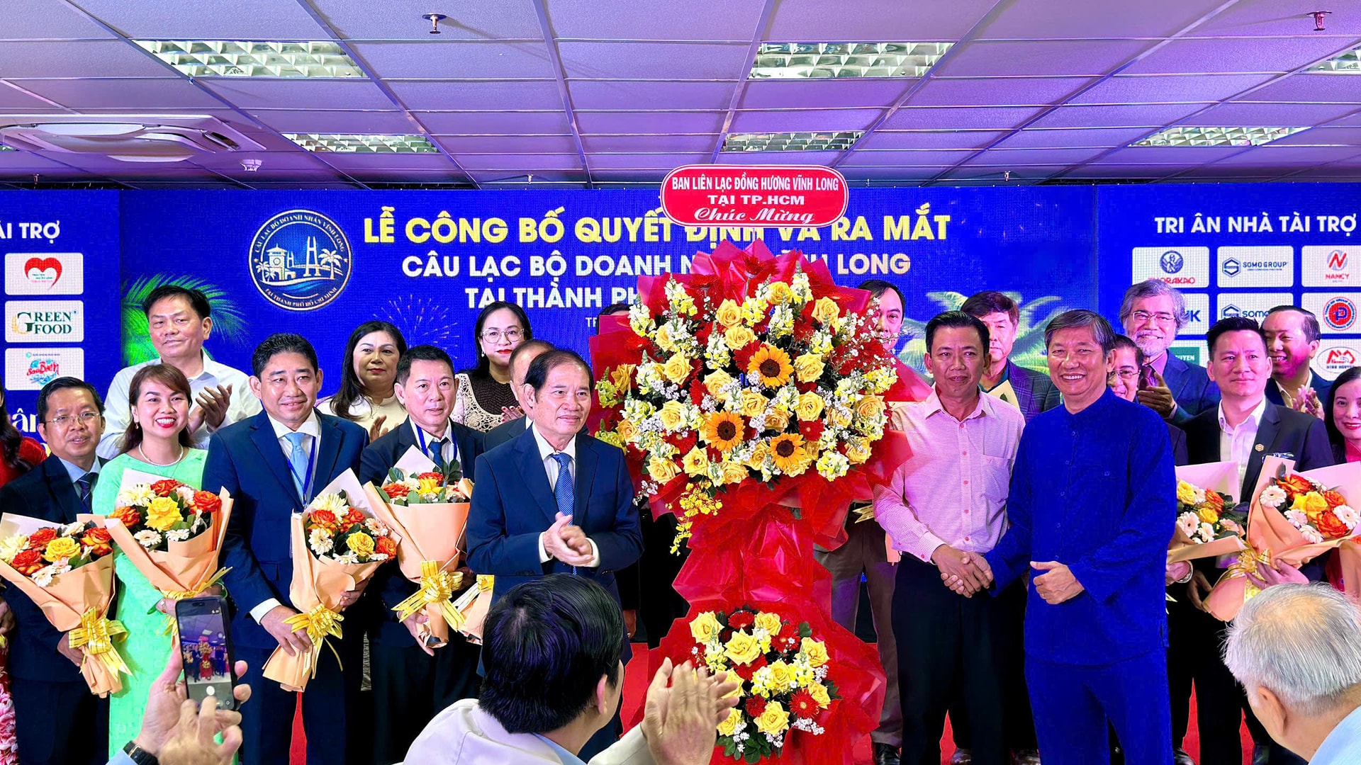 Các thành viên trong CLB Doanh nhân Vĩnh Long nhận hoa chúc mừng trong buổi ra mắt tại TP.HCM sáng 8-2