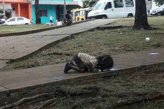 Bé gái giải khát bằng... liếm nước bẩn dưới đất tại Argentina